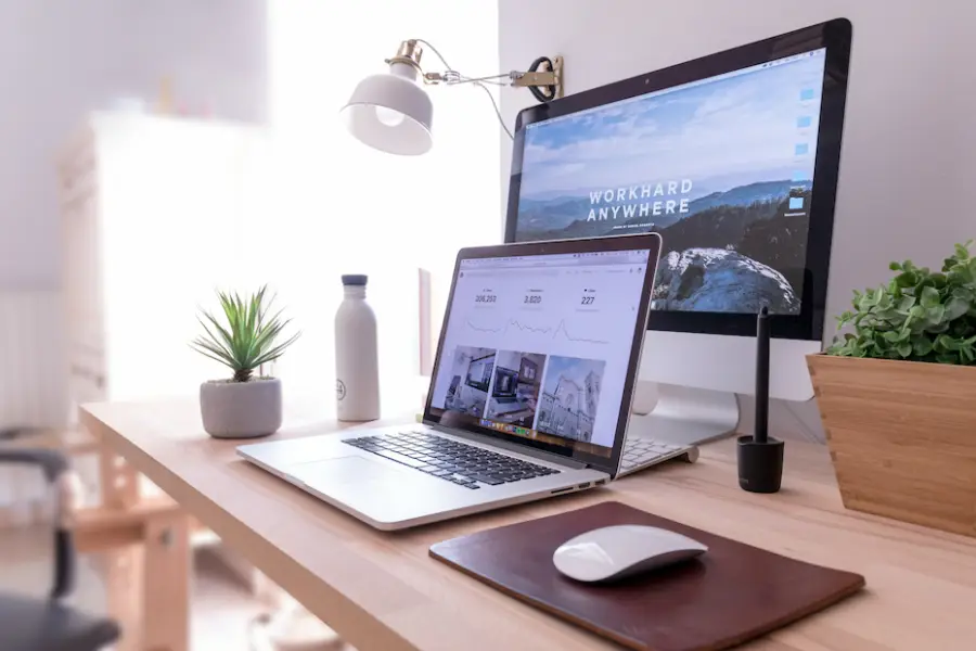 A tidy desk with a laptop and monitor, ready for a video call